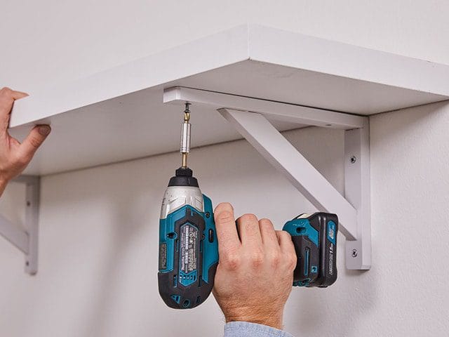 Handyman fixing shelves