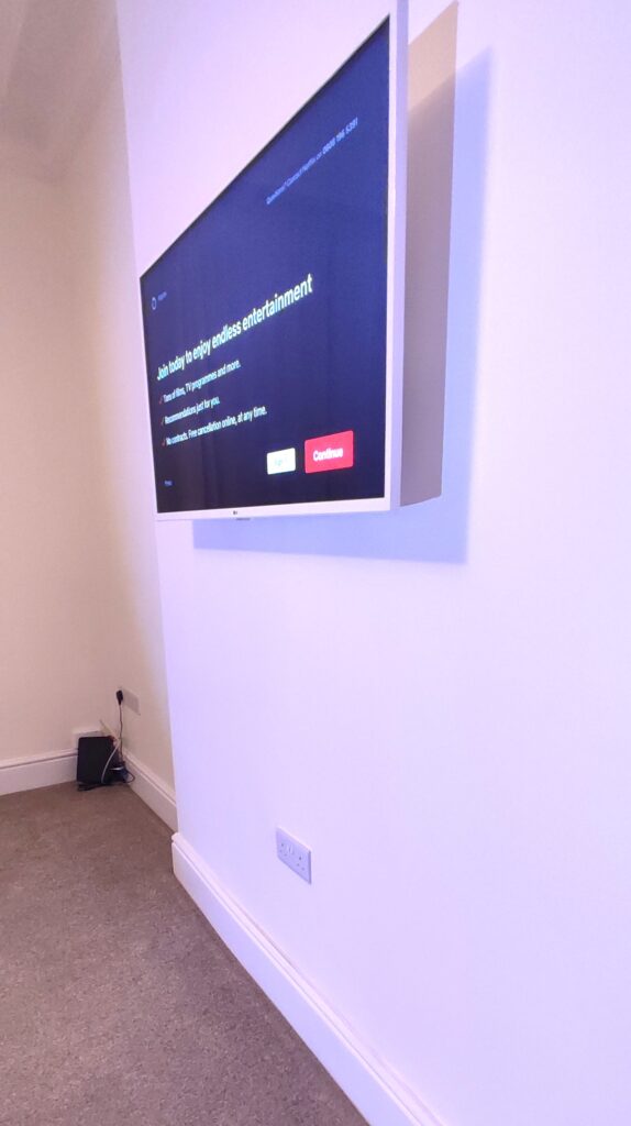 White TV mounted on a wall with cabling hidden behind wall