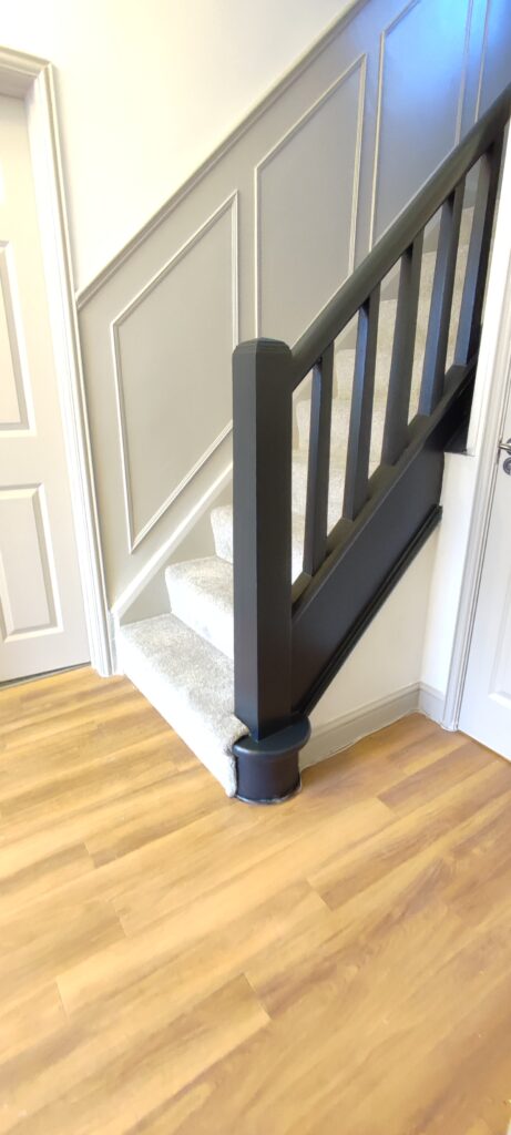 Wainscot wall panelling painted in Farrow & Ball 'Purbeck Stone' with bannister painted in Farrow & Ball 'Railings'